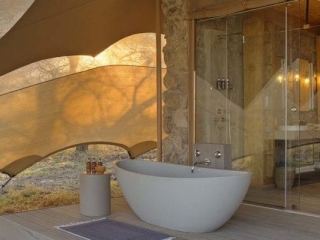 wetu_-_namiri_plains_-_tent_deck_with_bath_and_shower_looking_onto_the_plains