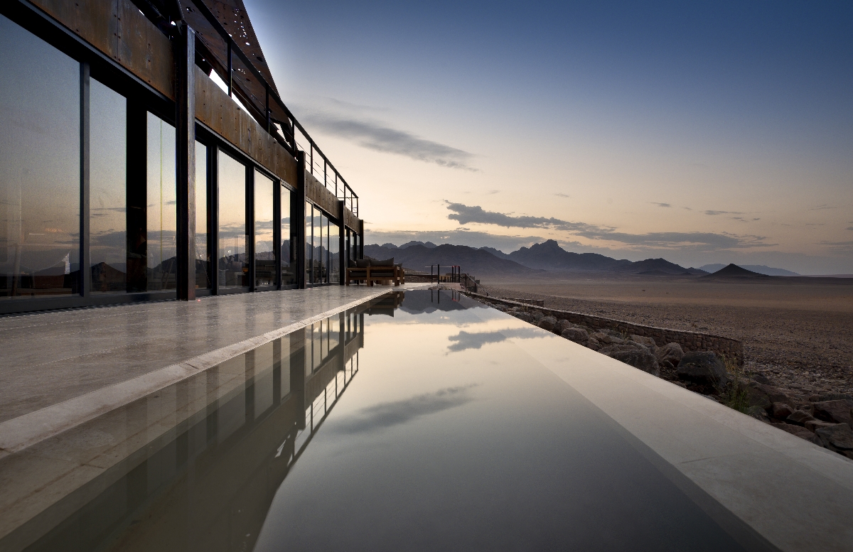 The still mirror of the reflection pool at &Beyond Sossusvlei Desert Lodge in Namibia reflection the perfect dusk sky