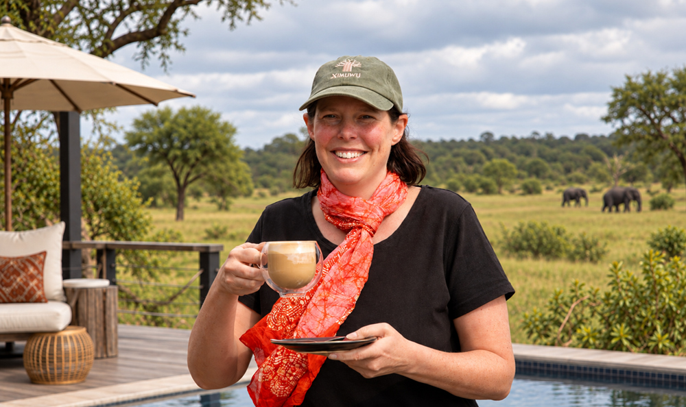 Lise Kargaard enjoying a coffee at Ximuwu Lodge with elephants in the background